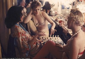 Это фото не похоже на светскую жизнь, это гримерка, рассчитанная на большое количество прихорашивающихся, девушки скорей всего танцовщицы, у двоих из них что-то вроде бус-бретелек одинаковые