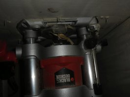 Да. На первой фотке виден винт, гайка присыпана опилками, на второй, внизу пластмассовая головка винта. Ручку с кнопкой подразобрал и повернул, что бы не мешала подъёму. Регулировкой глубины резания, отрегулировал максимальный подъём без упора в стол.