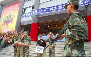 Пришлось искать пути информационного самоудавлетварения в данном вопросе

Перевод на табличках:
Справа - Захватил и Ограбил 
Слева - Изготовил пистолет

А вот немного выясненных подробностей:

Подозреваемых выставили на всеобщее обозрение перед ступеньками торгового центра, где произошло ограбление. За подобное преступление максимальное наказание в Китае смертная казнь. (ФОТО)

В провинции Шэньси полицейские задержали двух подозреваемых в ограблении ювелирного магазина. После задержания грабителей вывели на всеобщее обозрение.

Как сообщает агентство "Синьхуа", 9 мая в одном из городов провинции Шэньсин произошло дерзкое ограбление ювелирного магазина. Грабители ворвались в магазин средь бела дня и, угрожая ножом и топором, потребовали драгоценный товар. Добычей преступников стали 6 золотых браслетов, 59 золотых цепочек и 47 колье, общей стоимостью в 600 тысяч юаней (около 100 тысяч долларов). Забрав награбленное неизвестные скрылись.

В этот же день полиция объявила розыск и награду за поимку грабителей. Поиски продолжались несколько дней. По словам главы местной полиции задержание стало для них своего рода делом чести. И вскоре полицейским удалось задержать грабителей. Ими оказались двое молодых братьев Ян Лонфей и Ян Ке. Преступники не успели сбыть награбленное, и товар был торжественно возвращен владельцу магазина. 

Самих подозреваемых выставили на всеобщее обозрение перед ступеньками торгового центра, где произошло ограбление. За подобное преступление максимальное наказание в Китае смертная казнь.