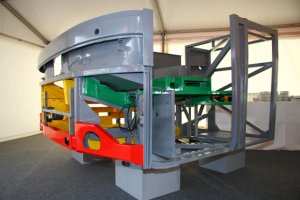 Для понимания. Противоподкатный брус специально делается деформируемым, посему он и выглядит достаточно легким. Его задача в числе прочего погасить/ рассеять кинетическую энергию автомобиля, бьющего в брус за счет ее затрат на деформацию конструкции. Можно навесить и рельсу, но тогда последствия будут много тяжелей: ударивший в нее автомобиль просто "размажет" по железке. Так что усиленный не допустим по соображениям безопасности. И то, что на некоторых машинах на фотографиях установлены подобные, это плохо. Однако формально не противоречит требованиям закона. А про запаски ерунда: это просто стандартное место их установки.
И еще. На современных грузовых автомобилях противоподкатная защита устанавливается "по кругу". Есть и более сложные конструкции - целые системы противоподкатной защиты. Например, на картинке макет FCG (Front Collision Guard): система устанавливается на автобусы Mercedes-Benz и Setra. Выделено цветом. Удар воспринимают красные элементы, они достаточно жесткие. И решают две задачи: (1) не допускают "глубокого" подъезда встречного автомобиля под автобус; (2) переносят удар на желтые элементы. Те, гасят кинетическую энергию удара за счет собственной деформации и более того переносят ее на элементы каркаса кузова, которые окончательно рассеивают ее, деформируясь сами. Зеленым цветом выделена недеформируемая платформа, на которой стоит сиденье водителя. Ее задача: сместить его дальше от рулевого колеса в глубину салона из зоны самых больших деформаций. Расстояние небольшое, но достаточное, чтобы снизить риск получения водителем критических травм при лобовом столкновении. На второй картинке показано, как это выглядит на реальном автобусе. В данном случае Mercedes-Benz Travego. Раскраска только для демонстрации, на обычных машинах ее нет.