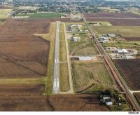 На приведённой в посте фотографии всё  что угодно, но только не международный аэропорт Камдо-Бамда (Qamdo Bamda)

Самое интересное, что эта фотография в интернете обязательно содержит подпись, что это аэропорт Камдо-Бамда. :)
На самом деле, это не так.
Здесь мы видим аэродром, расположенный на равнине.
Присмотритесь к рельефу окрестностей реального Камдо-Бамда: сплошные горы.
Затем, длина ВПП. Очевидно, что длина ВПП на фотографии не более пары километров, а длина ВПП Камдо-Бамда 4.000 метров плюс КПБ (концевая полоса безопасности) 1.400 метров.
Ну, и обратите внимание на МПУ (магнитный путевой угол) ВПП: на фотографии он 350 градусов и, соответственно, 170, а МПУ ВПП Камдо-Бамда 320 и 140 градусов.
На фотографии какой-то аэродром районного значения с соответствующей аэропортовской инфраструктурой, а в аэропорту Камдо-Бамда современный терминал.
Устарели данные в посте и по длине ВПП.
Сейчас длина ВПП Камдо-Бамда 4.000 метров и ещё 1.400 метров КПБ при рабочем курсе МПУ-140 градусов, что вывело Камдо-Бамда на первое место в мире среди гражданских аэродромов по длине ВПП.
То есть, для посадки экипаж может рассчитывать почти что на пять с половиной километров безопасного торможения.
Поэтому сегодня в Камдо-Бамда приземляются не только лёгкие самолёты с малой загрузкой, но и вполне нормальные самолёты.
Почему КПБ только с одной стороны ВПП? Скорее всего, для посадки и взлёта используется либо преимущественно, либо исключительно рабочий курс 140 градусов. Это может быть продиктовано препятствиями (горы) либо в зоне подхода, либо в зоне набора после взлёта с МПУ-320 градусов.
Рабочий курс МПУ-140 имеет и ILS (КГС)- видим и курсовой, (КРМ) и ГРМ (глиссадный) радиомаяки для МПУ-140, оборудован огнями подхода с курсом 140. Да и стартовый диспетчерский пункт (СДП) и метеоплощадка имеются лишь с курсом 140.