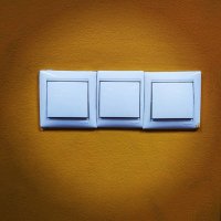 А это называется-Что купили,то и поставили.Стоял трёх местный выключатель в одной рамке.А купили три новых,а рамку новую нет.Вот и подпили средний.А что не ровно стоят- ну так видит установщик.