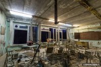 Не, порожне. Не так я это вижу. Надо вот эдак:
Поставьте парты и стулья, которые там найдёте, примерно так, как они стояли ранее. В божеский вид ничего приводить не надо. Остальное оставьте всё как есть. Потом рассадите учеников (настоящих детей) - как полагается: чистая, ухоженная, школьная форма середины 80-х, портфели рядом с партами. Поставьте училку  с указкой в руках перед доской, карту на доске натяните или биссектрису параллелограмма нарисуйте мелом - чётко, ярко выраженно, как будто бы только что училка её и нарисовала...
Жизни придайте - один тянет руку, другой ковыряется в носу, третий дёргает девчонку за косу, четвёртый - пухлик, бутер с колбасой и маслом жуёт тихонько под партой и т.д. На ваш вкус и цвет, в общем. А потом уж фотографируйте... = )

Или вот, пример для начинающих, 1-го уровня:
Поставьте газплиту на место. Ну и кухонный столик, если найдёте. Не нашли именно кухонный - тогда любой другой, не суть. В СССР с этим не особо заморачивались. Стулья расставьте. Пригласите пару человек - на роль мужа и на роль ребёнка (форма одежды - соответствующая "домашнему стилю" начала 80-х). Которые застынут на фотографии за столом "в ожидании ужина".

Хозяюшки с поварёшкой не хватает, верно? И дымящейся кастрюли на плите. Ясное дело - искусственное освещение добавьте. Ведь за окном будет поздний вечер - муж только что пришёл с работы, ребёнок дурака валяет уже который час, с тех пор, как явился с "продлёнки" = )
***
А после ужина все вместе смотрят новёхонький, только что купленный, цветной телевизор марки "Рубин". Сначала телепередачу "Спокойной ночи, малыши!" А затем "Время" - информационную телевизионную программу Центрального телевидения Гостелерадио СССР:
 
...блджад! Да какого хера я до сих пор придумываю всё это для человека, который потом невозбранно воспользуется моими идеями? Будь он проклят, короче. Пусть сам дальше выдумывает. А мне недосуг = )