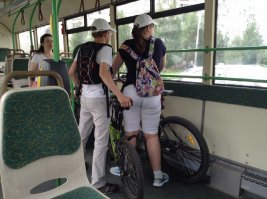 Здесь вполне логично: ребята едут покататься на велосипедах, например, по парку или в специально оборудованные места для катания на велосах. Дети маленькие, по фото видно. Самостоятельно пересекать проезжие части на велосипедах боятся. Вот и добираются на общественном транспорте.