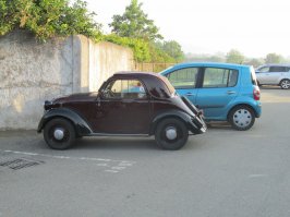 Мне прошлым летом повезло на Сицилии познакомится с владельцем небольшой коллекции ретроавтомобилей. Он, увидев мою страсть посадил меня за руль и мы с ним немного покатались. Очень он был удивлен тем, что я знаю, что такое подсос и умею делать перегазовку и двойной выжим. После этого он мне отдал ключи от этого Тополино ( 1947 г.)и сказал "Катайся". Я семью покатал, удовольствие бешеное получил. Как ни странно тачка четырехместная. А движок расположен в коротеньком свесе между бампером и передней осью. Остальное место под капотом - это пространство для ног.
Я отдал деду тачу, благодарил долго. Коробку Коркунова подарил и через неделю он пригнал мне здоровенный Фиат 1935 года и тоже отдал ключи.
Мне Сицилия не понравилась, но люди там ( и не только этот дед) замечательные.