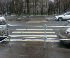 А вот тут не все так просто.  
Часто бывает, что переход убирается с этого места - снимаются знаки, даже предпринимается попытка затереть "зебру", но пешеходы по привычке продолжают буром ломиться по своей натоптанной тропе. И тогда единственный выход - перегородить проход барьерами. И то, не всегда помогает - особо упертые или упоротые и через барьер перелезают. 
Возможно, на фото как раз промежуточный этап реконструкции дороги