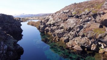 Силфра (Silfra) - ущелье, которое является частью Атлантического разлома и разделительной линией между континентами Европа и Америка и находится в национальном парке Тингвеллир (Thingvellir) в Исландии. Силфра - это излюбленное место для дайверов, вода здесь настолько чистая, что ее можно даже пить

В ущелье Силфра вода холодная (в течение всего года составляет лишь 2-4 градуса Цельсия) и чистая, настолько, что ее можно пить. Все дело в том, что вода в ущелье появляется благодаря таянию ледника на горе Hofsjokull, и прежде чем попасть в Силфру она проходит все круги природной очистки. Ущелье пользуется огромной популярностью у дайверов, ведь видимость в воде составляет до 300 метров, а проплывая по нему можно коснуться одновременно обеих частей света   Европы и Америки. Также Силфра поражает своей красотой подводного мира.

Ущелье разделяется на 3 секции: Silfra Hall (Зал), Silfra Cathedral (Ущелье) и Silfra Lagoon (Лагуна). Когда только погружаетесь в ущелье, Вы попадаете в первую секцию, проплыв этот "зал", далее попадаете в само ущелье, которое, пожалуй, самое красивое, здесь как раз и соединяются континенты. Глубина этого участка составляет - 20 метров, а длина от одной стены ущелья до другой около 200-300 метров. Проплыв этот участок, Вы попадаете в подводное озеро (лагуну), глубина которого около 2 метров, и диаметром около 150 метров, это заключительная часть путешествия в ущелье.
