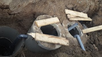 В текст особо не вчитывался, сразу замечу! 
1. Не учтена глубина промерзания почвы, мне показалось переливы высоко к поверхности, могут и замерзнуть.
2. С вытяжкой напутано! Вытяжка должна делаться через стояк в доме и на крышу, а вот приток воздуха у забора и низко к земле. Тогда и вони не будет и бактерии дышат. 
Я сделал ввод и переливы на глубине 1,6м. Колодцы по 3 кольца и дренажный колодец 2 кольца.