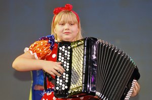 Маленькая девочка спит на чемодане в аэропорте