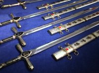 Меч Победы



 Меч Победы  представляет собой образец авторского, художественно украшенного, длинноклинкового оружия, покрыт золотом высшей 999,9 пробы. Особую парадность изделию придает инкрустация полудрагоценными уральскими камнями: гранатом, символизирующим пролитую кровь, и голубым топазом - символом мира. Длина клинка составляет 1,2 метра, а вес - более 5 килограммов. Клинок  Меча Победы  выполнен из высоколегированной стали, отличающейся особой твердостью и упругостью. Его украшает растительный орнамент и дарственная надпись. На другой стороне изделия высечены знаменитые слова Александра Невского: "Кто с мечом к нам придет, тот от меча и погибнет". Всего изготовлено 9 мечей.