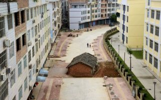 Ведь там на самом деле по домику бульдозер плачет! 
НО! ЦИВИЛИЗОВАННО! нужно это делать - компенсировать хозяину ущерб. 
Мне кажется, для того в палатке на дороге и живут, чтоб денег поболее выклянчить. 
Был бы им нужен этот дом - не доводили бы его до такого состояния.