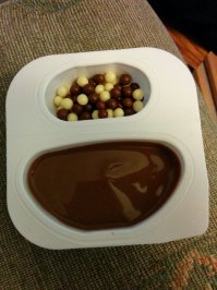 В большинстве своём   работы фотошколошоперов 80-го уровня и, разумеется, никаких серьезных изданий. Что касается "парящего" йогурта   то тут никакого фотошопа! Йогурт с маленьким контейнером (с джемом, например) представляете себе? У Muller Pud тоже такой есть. Вот поэтому, что  "главная героиня", что мадама на заднем плане и держат его как раз за этот крохотный контейнер или за бортик   чтоб не перекрывать этикетку. 

Так что это скорее вопрос к маркетологам от бога, которые посчитали, что так они покажут "как надо" держать их пудинг, тип своя фишка. Но вышло, что вышло. Однако фотошопа, по крайней мере, на стаканчике нет! :)