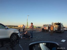 ""...на полосе движения МКАД в технически неисправном состоянии стояла Toyota Starlet (было повреждено либо отвалилось колесо), не была обозначена знаком аварийной остановки. Водитель смогла удержать машину в полосе и остановиться,   сообщил подробности случившегося официальный представитель УСК по Минску Алексей Климович.   Девушка решила выставить знак не сразу, а еще некоторое время просто стояла возле машины. Увидев случившееся, другой автомобилист остановился в  кармане , подошел к неисправному авто и предложил женщине выставить знак аварийной остановки и уйти с проезжей части. В этот момент Audi сначала налетела на отвалившееся колесо, а затем врезалась в Toyota, сбив при этом женщину. Решивший ей помочь свидетель успел отскочить...""