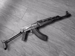 На моей фото сверху однозначно один из первых АК-47 участвовавший в конкурсе.

На вашем фото сверху прототип именуемый АК-47с уже внесенным рядом изменений. Он очень похож на КБ-П-580 - второе поколение прототипов АК-47. 
Можно заметить, что рукоятка перезаряжания на затворе цилиндрического типа, а не лепесткового. Внесены ли другие доработки, например: увеличен ли диаметр боевой пружины, изменена ли пружина выбрасывателя, не понятно, но уже точно реализован механизм фиксации и выброса пенала. 

НО одно можно сказать точно - это еще не АК, это прототип.

Поймите простую мысль, изменений внесенные в АК-47 в процессе и по результатам испытаний, как конкурсных так и войсковых - были десятки. Но они по отдельности не делали из АК-47 принятым на вооружение и всем известным АК.