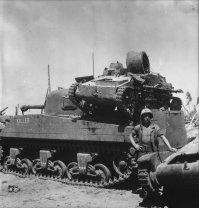 Интересный факт, о доп. защите шерманов. На фото видно обшитые досками борта, от кумулятивных мин, но по сути упростили задачу японцам=)
Японская куммулятивная мина на шесте имела конический некрашенный алюминиевый или стальной корпус с тремя шипами в донной части. Внутри мины находилась взрывчатка с куммулятивной воронкой, а в верхней узкой части размещался взрыватель. На мине мог быть стандартный взрыватель от ручной гранаты или комплект из капсуля, запала и детонатора. К вершине конической мины была привинчена металлическая трубка, в которую вставлялся деревянный шест с ударником на конце. Между детонатором и ударником находилась предохранительная скоба и меднная проволока. После выдёргивания предохранительной скобы, солдат, удерживая деревянный шест с противоположной от мины стороны, ударял шипами в цель с достаточной силой, чтобы смять медную проволоку между ударником и детонатором и разбить ударником капсуль в детонаторе.
Дополнительная защита американской бронетехники
Куммулятивная струя пробивала до 6 дюймов брони, если корпус мины вплотную прилегал к поверхности цели. Если мина оказыывалась под углом 60 градусов от вертикали к поверхности цели, тогда пробивалось до 4 дюймов брони.
"JAPANESE TANK AND ANTITANK WARFARE"
SPECIAL SERIES NO. 34
1 AUGUST 1945
MILITARY INTELLIGENCE DIVISION
WAR DEPARTMENЕ WASHINGTON, D. C.