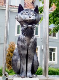 Я живу в городе Зеленоградске Калининградской области. Символом нашего города-курорта является кот. Есть множество скульптур с этим нашим символом. И даже музей "Мурариум" в бывшей водонапорной башне. Но главный скульптурный символ не просто скульптура, а ещё и карусель. "Зеленоградский кот в окне" вращается и детки с огромным удовольствием катаются вместе с котом. Совсем недавно установили кота на набержной, а чуть ранее около пожарки (к сожалению нет фото, но приезжайте в гости и смотрите). Вот фото музея, кота в окне и деревянной группы возле кафе.