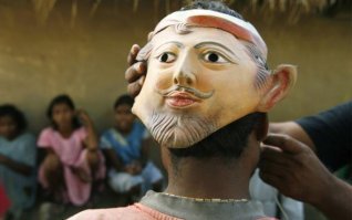 В Индии люди, заходя в лес, надевают маску на затылок. Зачем?  ПО всей вероятности, чтобы звери, желающие напасть на сей вкусный движущийся объект, столкнулись с нарисованным взглядом человека, то-есть с его ГЛАЗАМИ (на затылке человека!)и немного подумали о своём некрасивом поведении. Тем более, что взгляд это будет ВЫШЕ линии глаз тех же тигров, а значит, и "ЗВЕРЬ, ОБЛАДАЮЩИМЙ ЭТИМИ ГЛАЗАМИ, ИМЕЕТ УБИЙСТВЕННЫЕ и нехорошие, опасные для нападающего габариты!!!", по здравому рассуждению полосатого разбойника, и не только его. Мало ли таких умных животных в тамошних лесах? ;)
О ФОТО -- на затылок собирателя мёда надевают маску. Житель деревни должен отправиться в Сундарбанский лес, что на самом краю востока Индии. Это дом самой большой в мире популяции тигров. А также 4 000 000 самых бедных людей в Индии. Верят местные жители, что тигр никогда не нападает на человека спереди. Поэтому и носят маску, чтобы отпугнуть их. Ну не предлагает ООН шокеры, что ты будешь делать! И тигру было бы хорошо, и мёд был бы собран без последствий. Всё по отношению к Матушке Природе должно быть в рамках приличий.