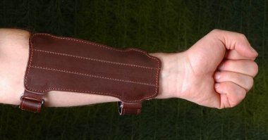 На "лучную" руку надевают крагу - по сути, манжету, защищающую предплечье. Большой палец там не может пострадать при всем желании.