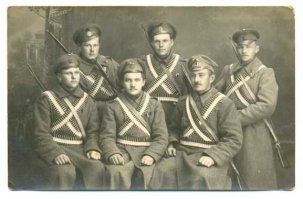 Всё достаточно прозаично 
Всё пошло от "берданки", как её называли солдаты или, по научному, от винтовки Бердана (калибра "четыре линии", точнее 4,2 линии, то есть - 10,67 мм). "Берданка", коей была вооружена русская армия до принятия на вооружение винтовки Мосина, была однозарядной. То есть после каждого выстрела полагалось открыть затвор, вынуть стрелянную гильзу, вложить новый патрон, закрыть затвор.
Пулеметы Максима питались матерчатыми (позже - металлическими) лентами по 250 патронов в каждой.
Находчивые солдаты сразу же заметили что кусок ленты - это готовый патронташ! И если привязать ее через грудь, то вынимать из нее патроны (особенно при стрельбе из положения лежа) гораздо удобнее и быстрее. А быстрее стреляющий солдат - более долго живущий солдат... Но не стоит забывать, что дело происходило в царской старорежимной армии и никаких вольностей в солдатском обмундировании быть не могло. Перепоясывание лентами было возможно только в так называемых "пластунских" полках (так называли соединения из снайперов и разведчиков), где царила более вольная обстановка, так как туда набирались бойцы отчаянные, самостоятельные и способные думать нестандартно.
С принятием на вооружение винтовки Мосина - знаменитой "трехлинейки" (калибр "три линии", 7,62 мм), "берданки" стали покидать воинские части. Винтовка Мосина во многом превосходила старую берданку. Несмотря на значительно меньший калибр, она имела бОльшую "мощь". То есть пуля имела бОльшую начальную энергию. Это увеличило бронепробиваемость и прицельную дальность стрельбы в несколько раз. Да и патрон весил меньше, что позволяло пехотинцу при той же загрузке носить больше боеприпасов.
Так для чего ленты? - спросите вы. А я отвечу: "Мода - страшная сила!". В незамысловатых солдатских мозгах закрепился стереотип, что так одевались самые элитные и уважаемые в войсках "пластуны". И вот как только во время революции перестали наказывать за вольности в обмундировании, все нарядились "под пластунов". Понты - сильнее смерти! Смешно? Наверное. Но матросики, в результате, не были изобретателями этой "моды", они эту "моду" просто подхватили.