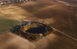 Это место называется Кратер Лохнагар. Находится этот Кратер во Франции недалеко от реки Сомме на севере страны. Именно там во время Первой Мировой войны велись наиболее тяжелые позиционные сражения между противоборствующими сторонами. Британские саперы прорыли тоннель длиной 310 метров от своих позиций до германских окопов, после чего заложили около 27 тонн аммонала. Взрыв был произведён в 7:28 утра 1 июля 1916 года. Образовавшаяся воронка имела ширину 90 метров, глубину 30 метров. Звук взрыва, говорят, был слышан даже в Лондоне.