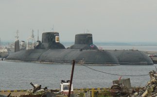 пипец эти лодки огромные.
у меня знакомый служил на такой (или на другой, но типа самой большой подлодке флота )
там внутри ппц говорит катакомбы, целый город. есть спортзал где в баскетбол можно играть, и бассейн. правда небольшого размера, но все равно. Коридоры широкие, потолки высокие. Горячая вода всегда есть. Третьим контуром охлаждения типа можно умываться. 
Ходили они к берегам США, всплывали в нейтральных водах, выходили на "палубу"  смотреть на америку)) Правда по пол года не всплывали. Зато на учениях стреляли такими ракетами. Ощущение говорит прикольное, сигнал, лодку трясет, шум, гул, а потом тишина.  
А это МБР полетела. А таких МБР как на фото грузят там целая куча. 
Глубину погружения по нитке определяли. Натягивали нитку между стенок отсека вроде, когда лодка на глубине и ее сдавливает вода нитка провисает. И чем глубже тем сильнее провисает. 
В момент погружения по коридору можно на жопе или на дыхательном аппарате...кататься как с горки. В общем подлодка пипец огромная. Размер даже сложно представить. Короче страшная машина.