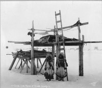 "Женщины готовят еду на улице, невзирая на мороз."
Ага - особенно бросается что ребёнок на морозе  раздетый и " душа " у женщины на морозе нараспашку . 

И вот это 

 Такие штуки строятся ,что-б хищники еду не крали ,а не из-за снега .