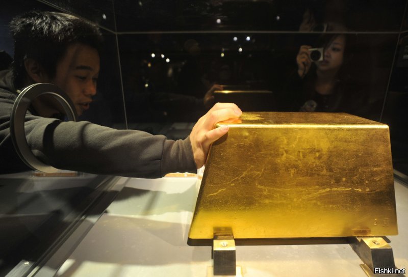 Посетитель касается самого крупного слитка золота в мире, вес которого составляет 220 кг (а стоимость превышает 7,8 миллионов долларов) в музее золота Джингуаши в Руифанге, Тайбэй, 2 декабря 2009 года.
