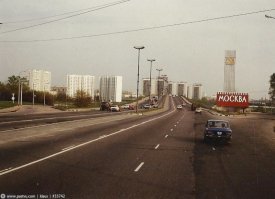 Это уже 80-е: старого арочного моста нет, построены три корпуса слева после моста. И лесобиржи справа, перед мостом, нет уже.