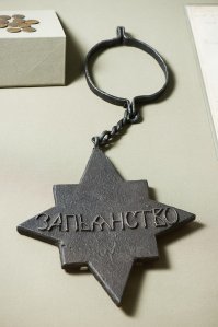 Раз так плотно ушло "в народ", более вероятна версия с наказанием в виде чугунной медали на шее. Вот об железку на шее и щёлкали, чтоб было понятно за чем пришёл "клиент".