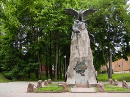 Чем то напомнило памятник в Смоленске.

Памятник Героям 1812 года, который находится в центре Смоленска у крепостной стены на аллее героев. 
Памятник Героям 1812 года отличается большим смыслом, который вложен в каждое решение скульптора. Большая каменная скала, символизирующая Россию, находится в основе монумента. По ней на верх пробирается воин с обнаженным мечом в руках   он является символом, который олицетворяет Наполеоновскую армию. На вершине скалы расположено гнездо, в котором возвышаются два бронзовых орла. Один из них вцепился в руку нападавшего война, а другой, прикрывая гнездо крыльями, готов в любую минуту броситься на неприятеля. Вся эта композиция символизирует объединение двух русских армий под Смоленском.

На памятнике закреплена бронзовая карта и надпись  Благодарная Россия героям 1812 г. . Также на монументе находятся имена главнокомандующих армий и большие бронзовые венки, в которые помещен двуглавый орел и герб Смоленск   райская птица на пушке. Имя этой птице   Феникс. Она каждый раз снова и снова восстает из пепла, как и город Смоленск, неоднократно разоренный и разрушенный неприятелями и захватчиками.
