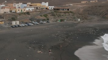 Тапочки никто не отменял. Однажды мне довелось в тропиках в солнечную погоду ступить на чёрный крупный песок, местами переходящий в мелкую гальку. Тут же помчался за тапочками, чтобы дойти до воды.
Фотка в пасмурную погоду. Название населённого пункта таково, что тут оно быстро зацензурируется.