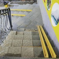 А чем вам этот пандус неугодил?

Да конечно чтобы им воспользоваться человеку в коляске нужна будет посторонняя помощь, но это лучше чем нести на руках.
На втором ярусе ступеней видна дополнительная направляющая чтобы убирать пандус когда в нём нет необходимости и не мешать остальным идущим.