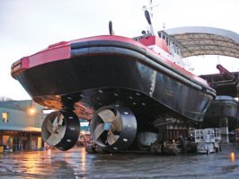 2. AZIMUTHING STERN-DRIVE TUG (ASD)    АЗИМУТАЛЬНЫЙ БУКСИР 

Azimuthing stern-drive tug (ASD)    Азимутальный буксир  - буксир с кормовым расположением азимутальных  полноповоротных  винторулевых колонок. Он подобен по типу традиционному двухвинтовому буксиру, однако обычный винт и гребной вал заменены на азимутальные винторулевые устройства.

Азимутальные устройства состоят из обычных винтов, оборудованных поворотными насадками, которые могут вращаться на 360 градусов для предоставления тяги в любом направлении без использования рулей.  Наиболее распространена конструкция, получившая название  Z-Drive  благодаря особенности вала который горизонтален на выходе из двигателя, вертикален по отношению к корпусу и снова горизонтален на ступице винта, в целом образует собой форму подобную букве  Z , также устанавливаются конструкции типа  L-Drive .

Как правило, буксиры типа ASD имеют буксирную лебедку на баке, но иногда и на корме. В большинстве случаев буксиры ASD используются как портовые буксиры, для сопровождения судов в акватории порта и в открытом море. Среднее  тяговое усилие составляет порядка 65 тонн (и более).