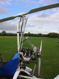 Посмотрел немного про автожиры. Кому вообще в голову пришло такое? Но я так и не понял - винт пассивный, он момент на корпус не передает, как следствие второй винт не нужен. Но получается, с такой конструкцией на месте не зависнуть уже, так?
И главное - а как они там крен делают? Вот тут я приложил фото одного из современных автожиров. Я тут автомата перекоса не вижу.