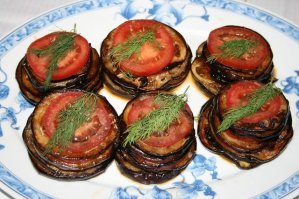 Рецепт КЛАССИКА:  жареные баклажаны с помидорами

    баклажан   2 шт.
    яйцо куриное - 3 шт.
    чеснок   1 зуб.
    помидоры свежие   3 шт.
    соль   по вкусу
    майонез   по вкусу (главное - ВООБЩЕ НЕ ПОРТИТЬ ИМ ЭТО БЛЮДО!)

Баклажаны нарезать кружочками. Чтобы впоследствии жареные баклажаны не горчили, их следует немного подготовить. Для этого посыпаем их солью и оставляем минут на 20-30, чтобы выделился сок, с которым уйдет горечь.
Моем помидоры и, не снимая кожуры, режем на тонкие кружочки.
Яйца бьём в миску, взбалтываем, солим.
Разогреваем сковороду с маслом на среднем огне, выкладываем баклажаны, предварительно обмакнув в яйцо, жарим с обеих сторон. 
По готовности овощи можно выложить на бумажное полотенце, которое впитает излишки масла (Фитнес вариант). 
Формируем блюдо. 
На каждой кружочек жареного баклажана кладем нарезанный помидор. Чистим чеснок и мелко нарезаем (я лично просто пользуюсь "чеснокодавкой").
Укладываем один на один, "слоями" - баклажан, помидор, чеснок;  баклажан, помидор, чеснок.

Можно посыпать зеленью (Чисто для красоты).

Рекомендую накрыть и убрать на пару часов в холодильник.

Приятного аппетита!