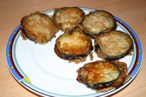 Рецепт КЛАССИКА:  жареные баклажаны с помидорами

    баклажан   2 шт.
    яйцо куриное - 3 шт.
    чеснок   1 зуб.
    помидоры свежие   3 шт.
    соль   по вкусу
    майонез   по вкусу (главное - ВООБЩЕ НЕ ПОРТИТЬ ИМ ЭТО БЛЮДО!)

Баклажаны нарезать кружочками. Чтобы впоследствии жареные баклажаны не горчили, их следует немного подготовить. Для этого посыпаем их солью и оставляем минут на 20-30, чтобы выделился сок, с которым уйдет горечь.
Моем помидоры и, не снимая кожуры, режем на тонкие кружочки.
Яйца бьём в миску, взбалтываем, солим.
Разогреваем сковороду с маслом на среднем огне, выкладываем баклажаны, предварительно обмакнув в яйцо, жарим с обеих сторон. 
По готовности овощи можно выложить на бумажное полотенце, которое впитает излишки масла (Фитнес вариант). 
Формируем блюдо. 
На каждой кружочек жареного баклажана кладем нарезанный помидор. Чистим чеснок и мелко нарезаем (я лично просто пользуюсь "чеснокодавкой").
Укладываем один на один, "слоями" - баклажан, помидор, чеснок;  баклажан, помидор, чеснок.

Можно посыпать зеленью (Чисто для красоты).

Рекомендую накрыть и убрать на пару часов в холодильник.

Приятного аппетита!