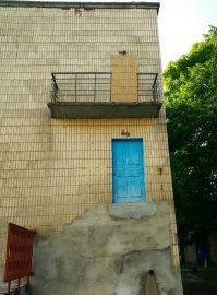 А что тут странного? Был аварийный выход, пожарная лестница, лестницу убрали, одну дверь заложили.