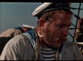 Ну не такой он и древний.....
Моряки носили серьгу как статусный признак.   Есть несколько версий.
- Знак отличия, означающий, что моряк пересекал экватор.
- Знак отличия, означающий, что моряк проходил пролив Дрейка, то есть обогнул Южную Америку.  У мыса Горн  почти круглый год стоит штормовая погода. 
 - Оберег, чтобы не утонуть.