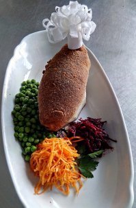 хороший вопрос
смотри на фото мною сделанная котлета
в чем прикол ,котлета подается как бы на  пьедестале из срезанного под определенным углом кусочком  хлеба. Прикол в том ,что внутри котлеты находится сливочное масло с пряностями. Ты берешь одной рукой за косточку она на фото в салфетке, а второй рукой ножом разрезаешь ее и масло должно вытечь и впитаться в хлебный пьедестал, а не на тарелку. То есть гренка должна пропитаться этим маслом, после она сьедается. Если кость убрать ,то эту процедуру будет очень тяжело проделать