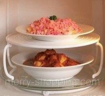 Ага, конечно время уменьшится вдвое, но вместо одной нагретой тарелки вы получите две полунагретые. Чем больше объем продуктов в микроволновке тем дольше время разогревания. Вы реально сэкономите не более 15 секунд - это время на смену тарелок. 
А если случайно поставите тарелку на стакане слишком близко к краю, то она при обороте может упасть ударившись об стенку, тогда мытье микроволновки с лихвой компенсирует все "сэкономленное" время. 
Если хотите реально по две тарелки ставить, лучше купите нормальную подставку.