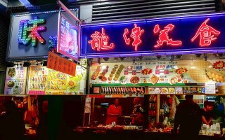 Прибрехивает актер, конечно, немного.

Вот ценник гонконгской уличной еды. В гонконгских долларах. 1 этот доллар = 0.13 американского. Т.е. 1 блюдо стоит доллар - полтора бакса (грубо). 

А ест он вряд ли 1 раз в день.
:)

Проезд в общественном транспорте - зависит от расстояния, но тоже не бесплатный - центов 30 -50. Американских. Т.е. только на транспорт в день доллар-другой уйти может легко.

Ну и прочие расходы, по мелочи. Зубная паста там, мыло и т.п. 

В 100 долларов в месяц не уложиться. Даже если за жилье не платить. 


В континентальном Китае, где-нибудь в провинции - можно прожить на сотню, вероятно. Но не в дорогом Гонконге. Хотя в то, что мужик скромный - охотно верю.