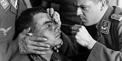 по моему это сбитому советскому лётчику немцы зашивают рану на лбу