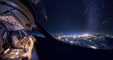 Он чего, боком летит? Вид в левое окно, а огни размыты поперек движения самолета