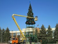 у нас искусственную  уже несколько лет ставят. днём стремновато выглядит ,а ночью когда горит норм.