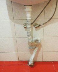 Просто не было нормального сифона под рукой, скреативили из чего было. Сделали гидрозатвор, чтобы из сливной трубы не воняло говнищем. Лечится, в отличие от других косяков - очень просто.