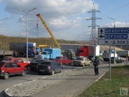 Проезжаю этот перекресток почти каждый день, и всегда ожидаешь, что подобное может произойти. 
Этот круговой перекресток находится внизу горы, и неместному водителю кажется, что дорога уходит налево, а там кольцо. 
За год его перелетают 2-3 грузовика, периодически дорогу сверху закрывают для движения грузовиков, знак стоит 40, куча предупреждений, и все равно постоянно бьются, говорят, что там должны построить нормальную развязку, но, как известно, денег нет.
В данном конкретном случае, рискну предположить, что очередной водитель "профессионал" радостно устроил гонку на "голове", но не учел, что она весит под 15 тонн, а задние колеса не загружены, добавьте к этому уклон и скользкую дорогу! Результат известен. Чудо, что все живы!

Вот смотрите "веселые" картинки с этого перекрестка... И это только те немногия, что я сходу нашел в интернете, не считая описанного ДТП.