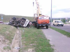 Проезжаю этот перекресток почти каждый день, и всегда ожидаешь, что подобное может произойти. 
Этот круговой перекресток находится внизу горы, и неместному водителю кажется, что дорога уходит налево, а там кольцо. 
За год его перелетают 2-3 грузовика, периодически дорогу сверху закрывают для движения грузовиков, знак стоит 40, куча предупреждений, и все равно постоянно бьются, говорят, что там должны построить нормальную развязку, но, как известно, денег нет.
В данном конкретном случае, рискну предположить, что очередной водитель "профессионал" радостно устроил гонку на "голове", но не учел, что она весит под 15 тонн, а задние колеса не загружены, добавьте к этому уклон и скользкую дорогу! Результат известен. Чудо, что все живы!

Вот смотрите "веселые" картинки с этого перекрестка... И это только те немногия, что я сходу нашел в интернете, не считая описанного ДТП.