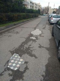 Больше похоже на то, что когда то тут была дорожка, выложенная декоративной плиткой, а потом поверх неё положили асфальт. Ну а со временем асфальт в некоторых местах протёрся.