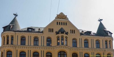 В 1910 году этот дом, как жилое и офисное здание, построил некий богатый латышский торговец, который не был принят в Большую гильдию. Торговец очень обиделся, и на крыше своего дома поставил двоих котов, хвостами обращенных к зданию Большой Гильдии, ясно показывая свое циническое отношение к гильдии и ее членам.   Вот это - сильно