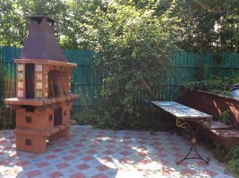 а вот наша садовая печь. Это готовая печь (под заказ), но я к ней приклеила каминным клеем суздальские изразцы. И столик по моему дизайну сделали в мастерской ковки.